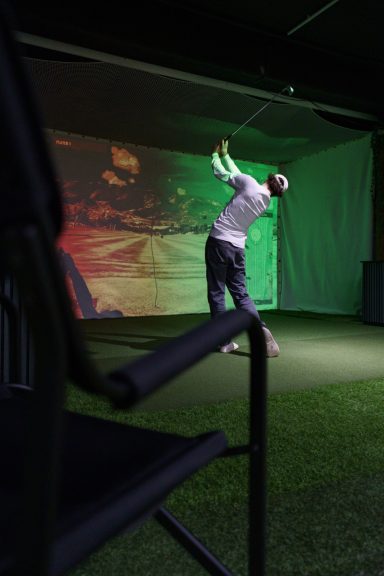 Person spielt am Simulator Golf